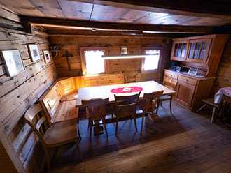 Bildbeschreibung: Wohnraum mit viel Naturholz und Kachelofen vom Ferienhaus Tgiasa Cao.