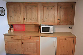 Bildbeschreibung: Innenaufnahme von der grosszügigen Küche mit Kochherd, Geschirrspüler und rustikaler Einfeuerung&nbsp; des Ferienhaus Tgiasa Cao.