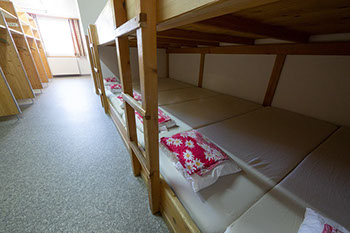 Bildbeschreibung: Kajüten- oder Hochbetten mit Stauraum in der Gruppenunterkunft für 20 Gäste.